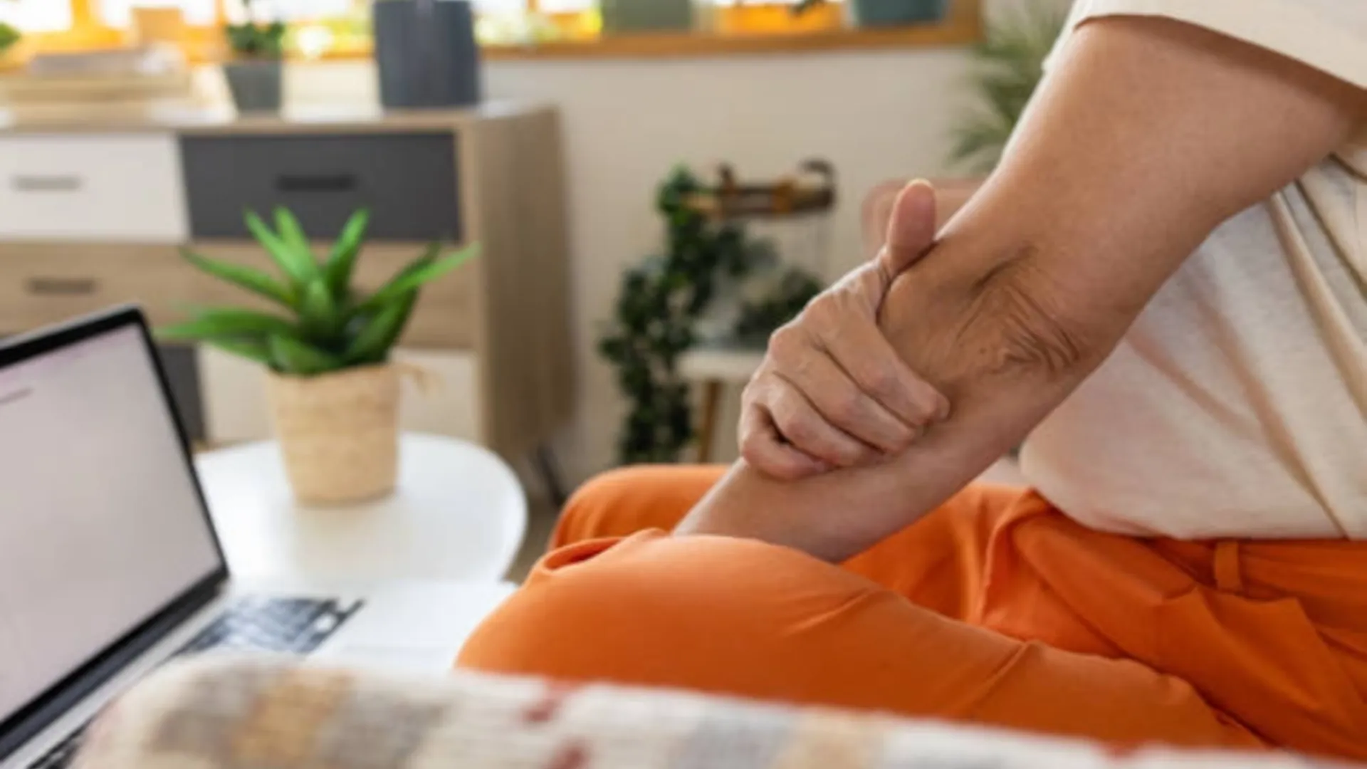 A woman is clutching her arm muscle in pain.