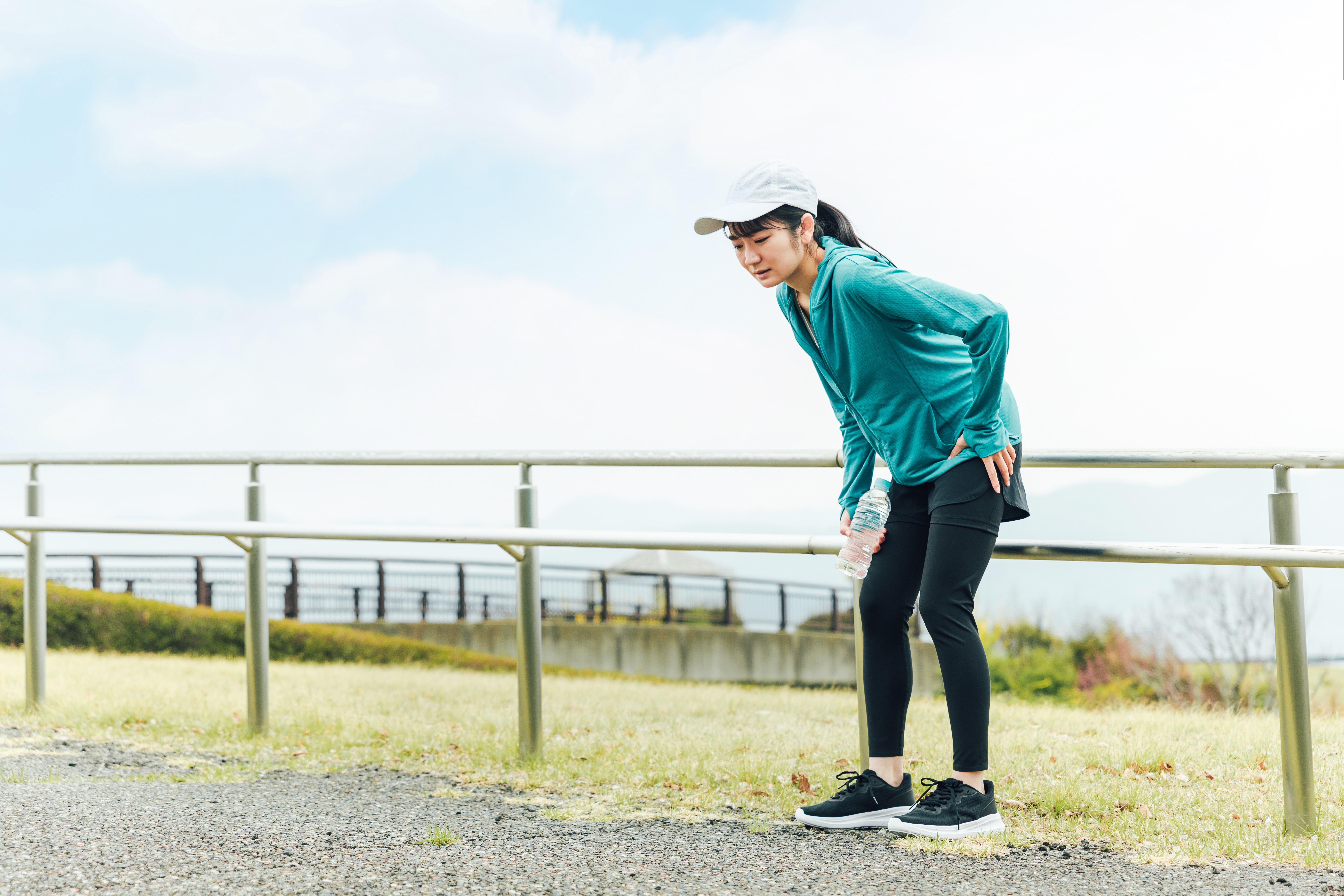 Women pausing run due to a sore leg